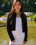 Tween in a black cardigan with bow buttons 