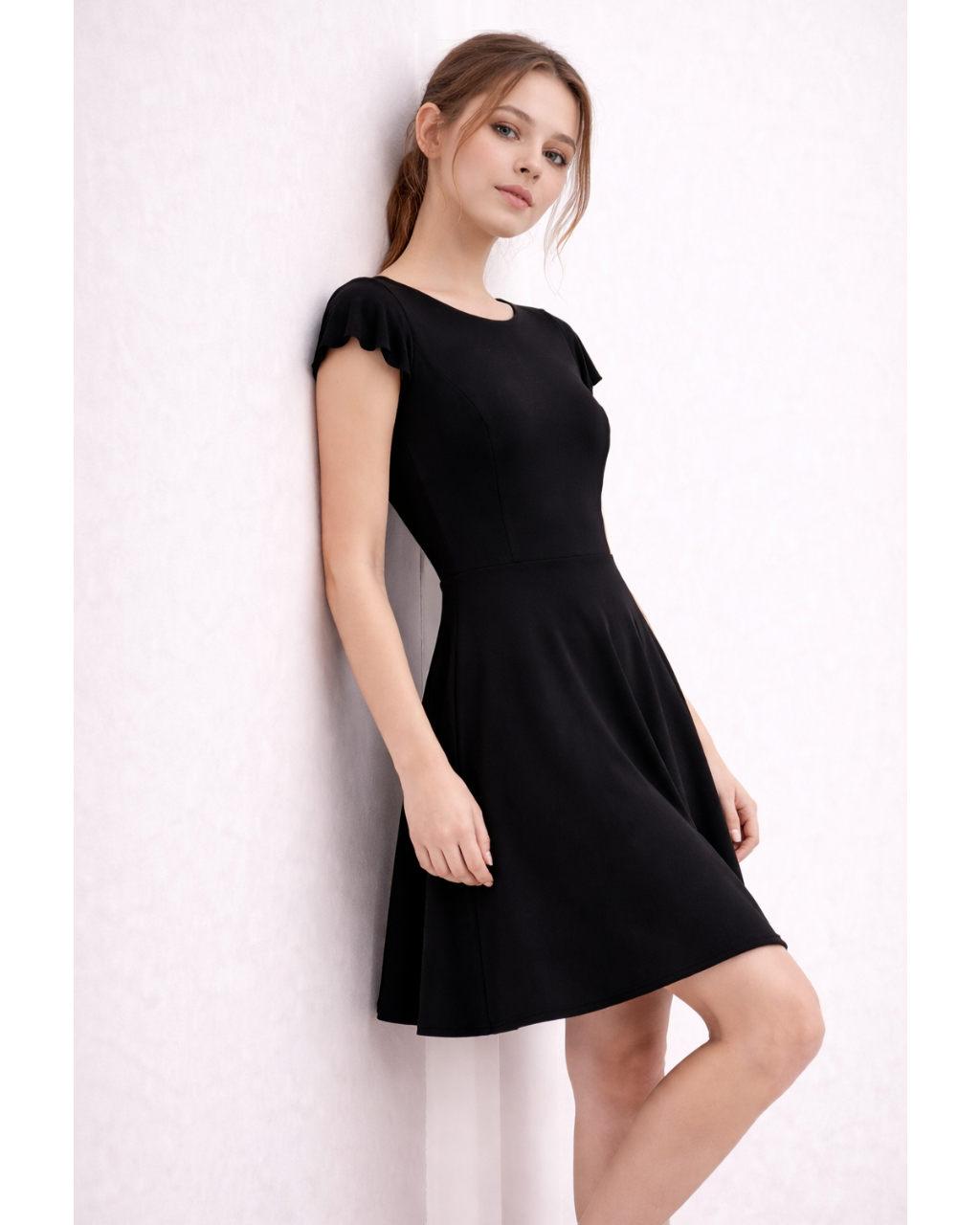 Woman wearing a black dress against a white background