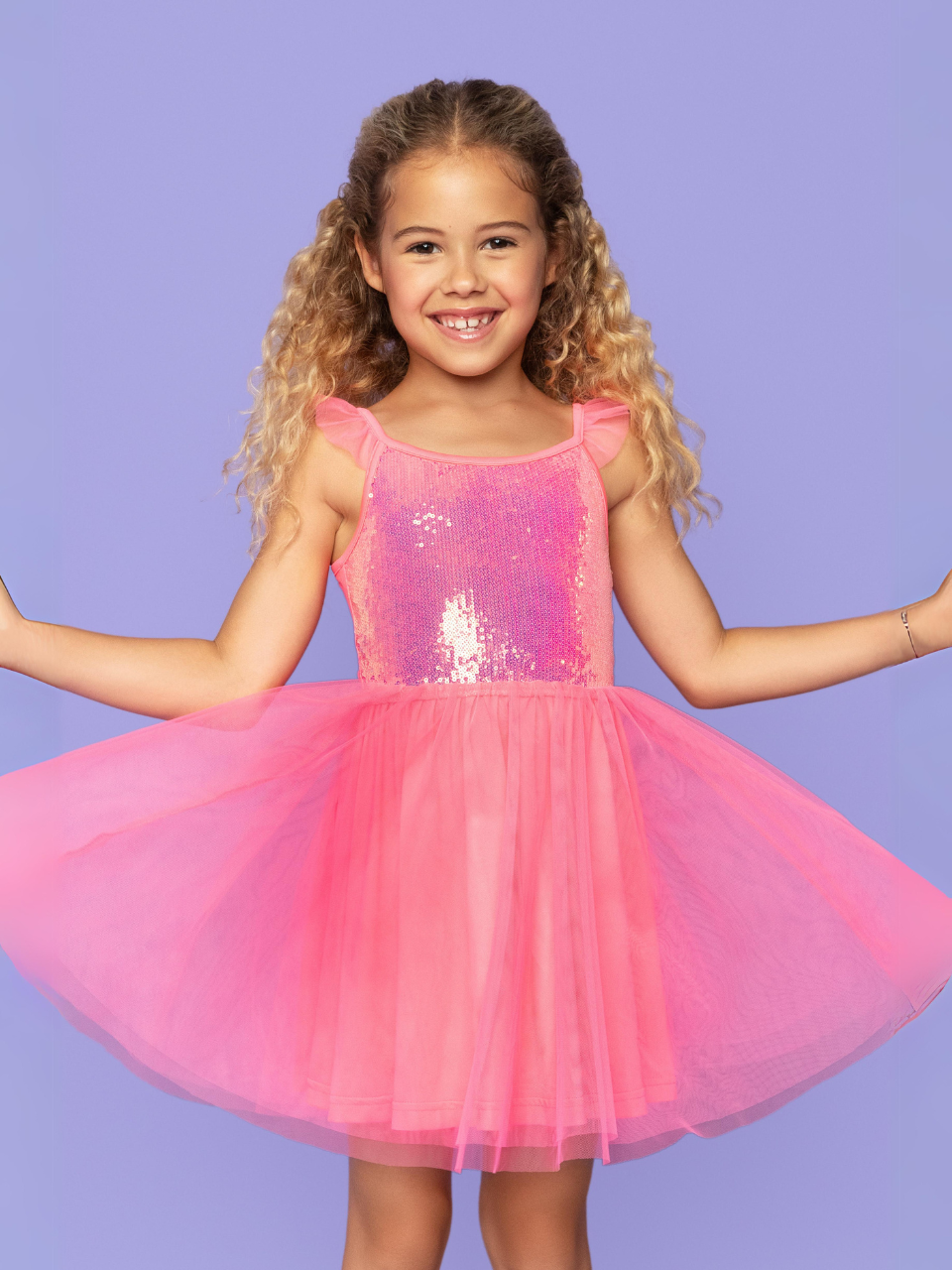 A young girl wearing a pink sequin dress.