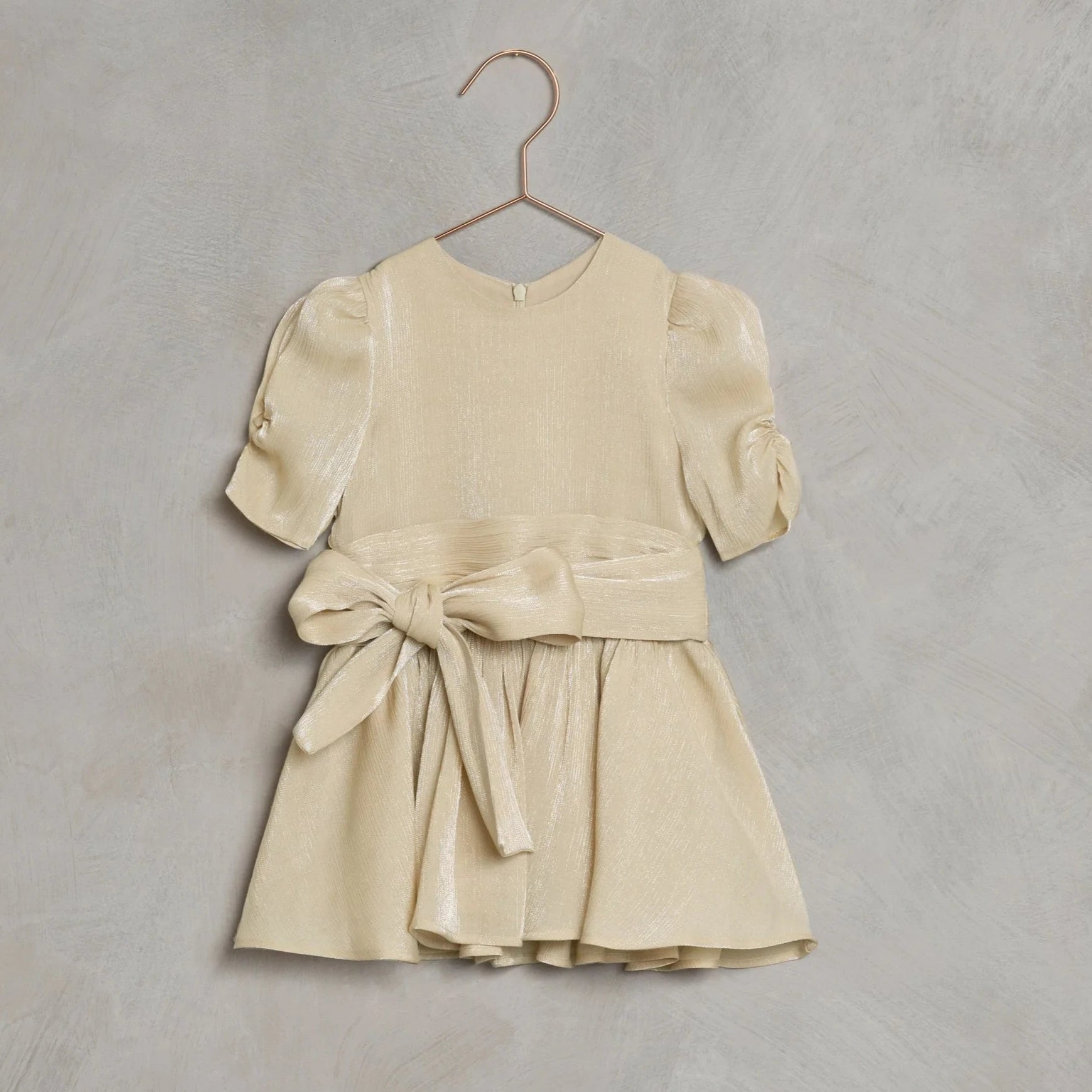 This Noralee ‘Josephine’ dress will make every girl feel special. It’s made from metallic tencel with our ‘metallic champagne’, a soft viscose liner, and has a bow at the waist. 